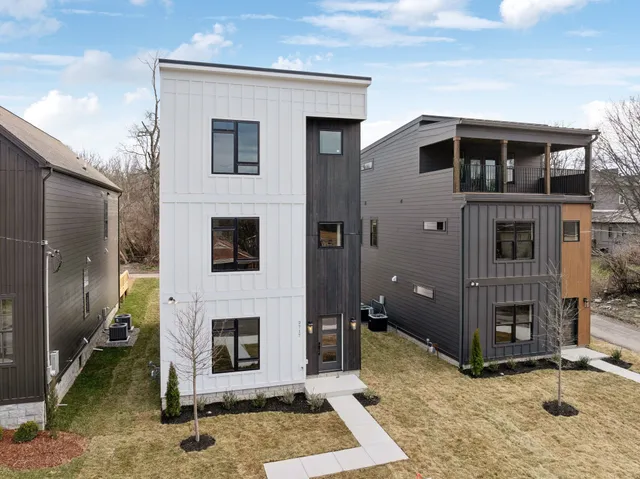 a view of a house with a barbeque and bench
