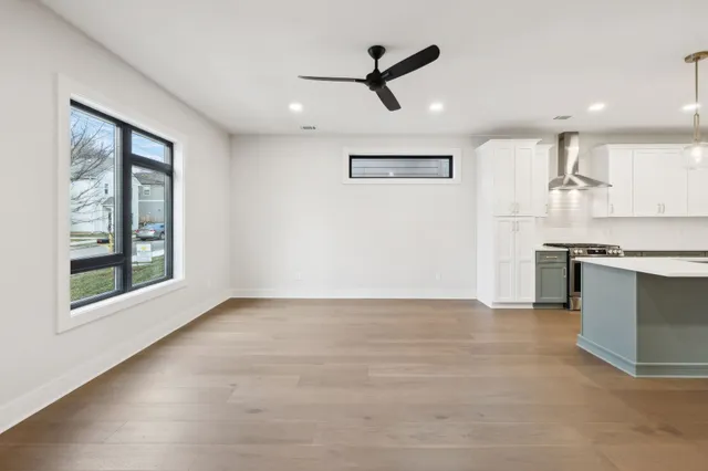 a view of a kitchen with stainless steel appliances wooden floor and a window