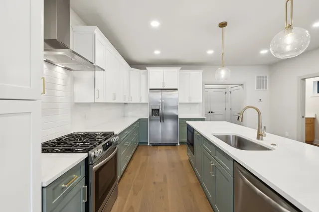 a kitchen with kitchen island granite countertop a sink stainless steel appliances and cabinets