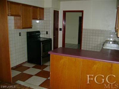 1437 Mandel Road Fort Myers, FL 33919 - Photo 6 of 8 a kitchen with a refrigerator and a stove