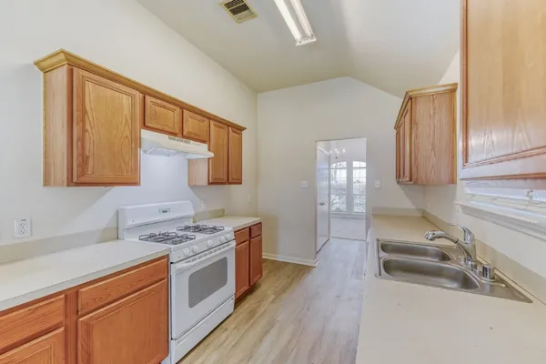 a kitchen with stainless steel appliances granite countertop a sink stove and cabinets