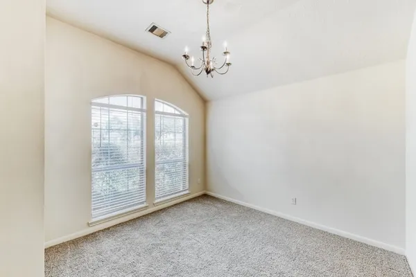 an empty room with windows and chandelier