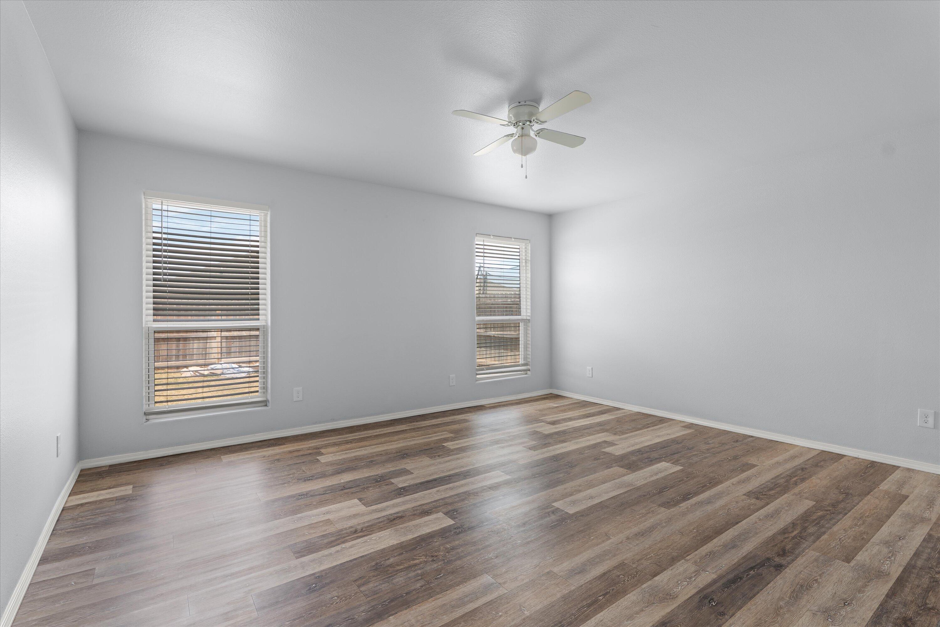 8414 11th Street Lubbock, TX 79416 - Photo 14 of 26 a view of an empty room with a window and wooden floor