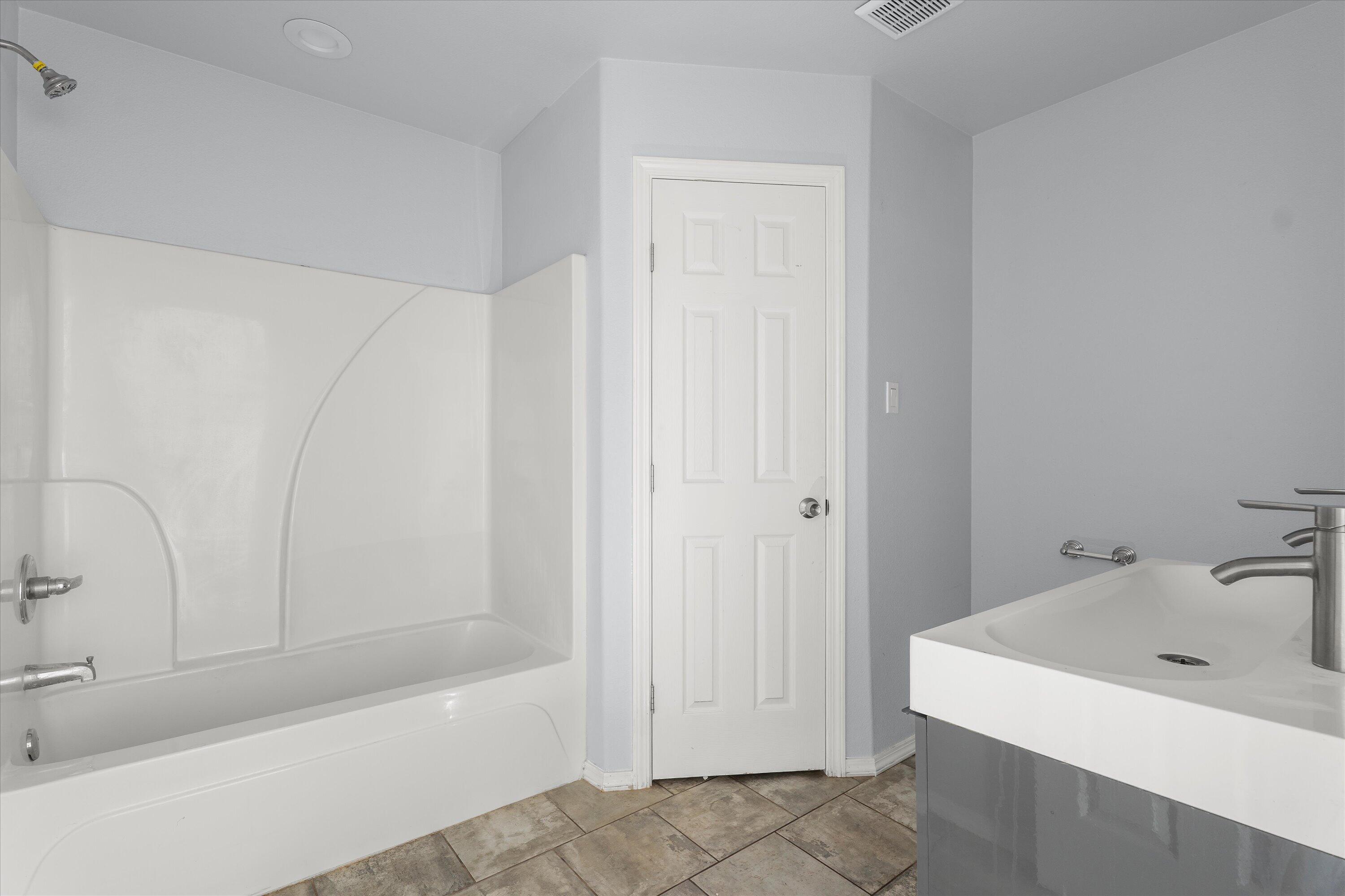 8414 11th Street Lubbock, TX 79416 - Photo 16 of 26 a bathroom with a bathtub and a sink
