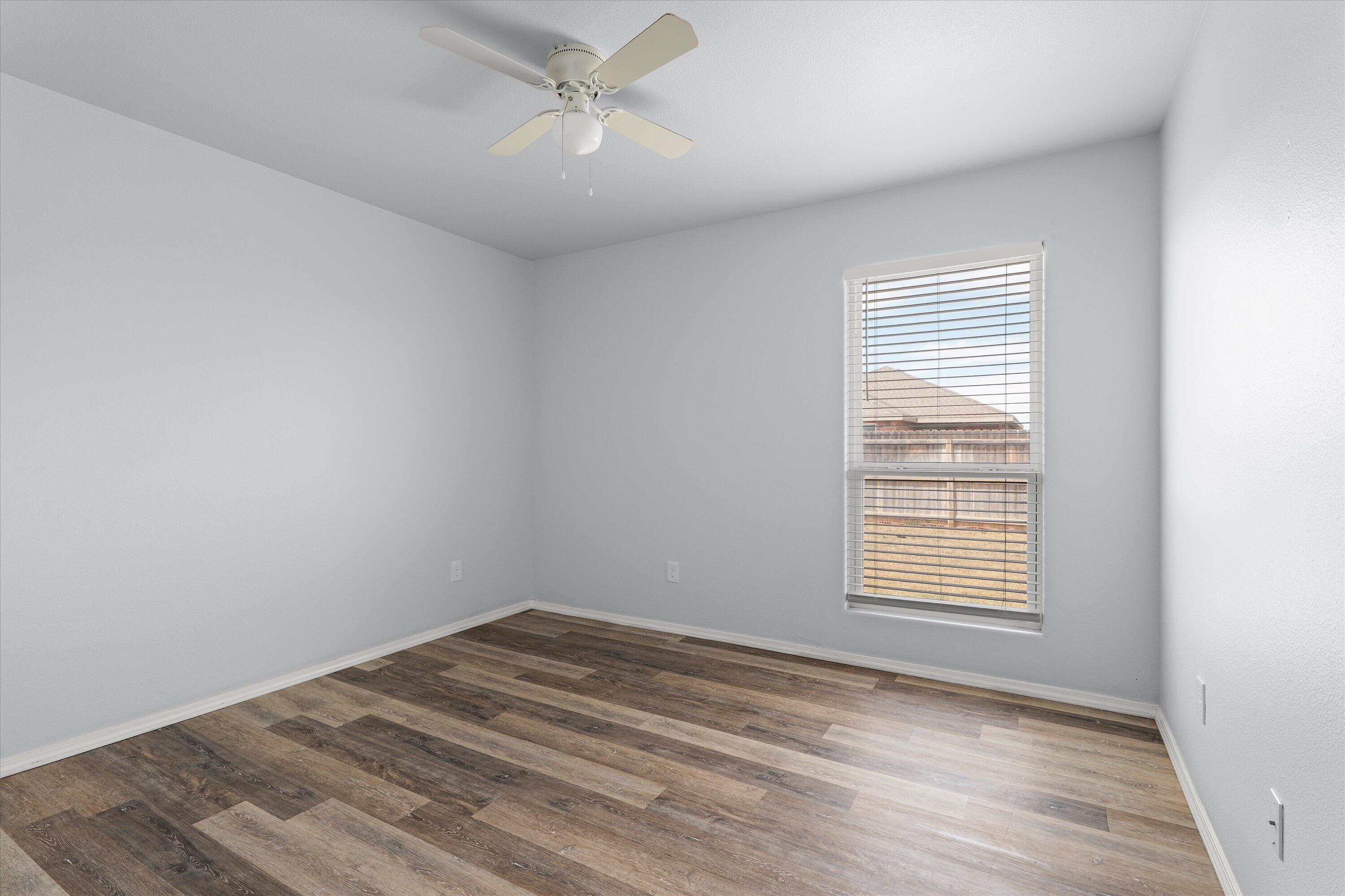 8414 11th Street Lubbock, TX 79416 - Photo 18 of 26 a view of empty room with wooden floor and fan