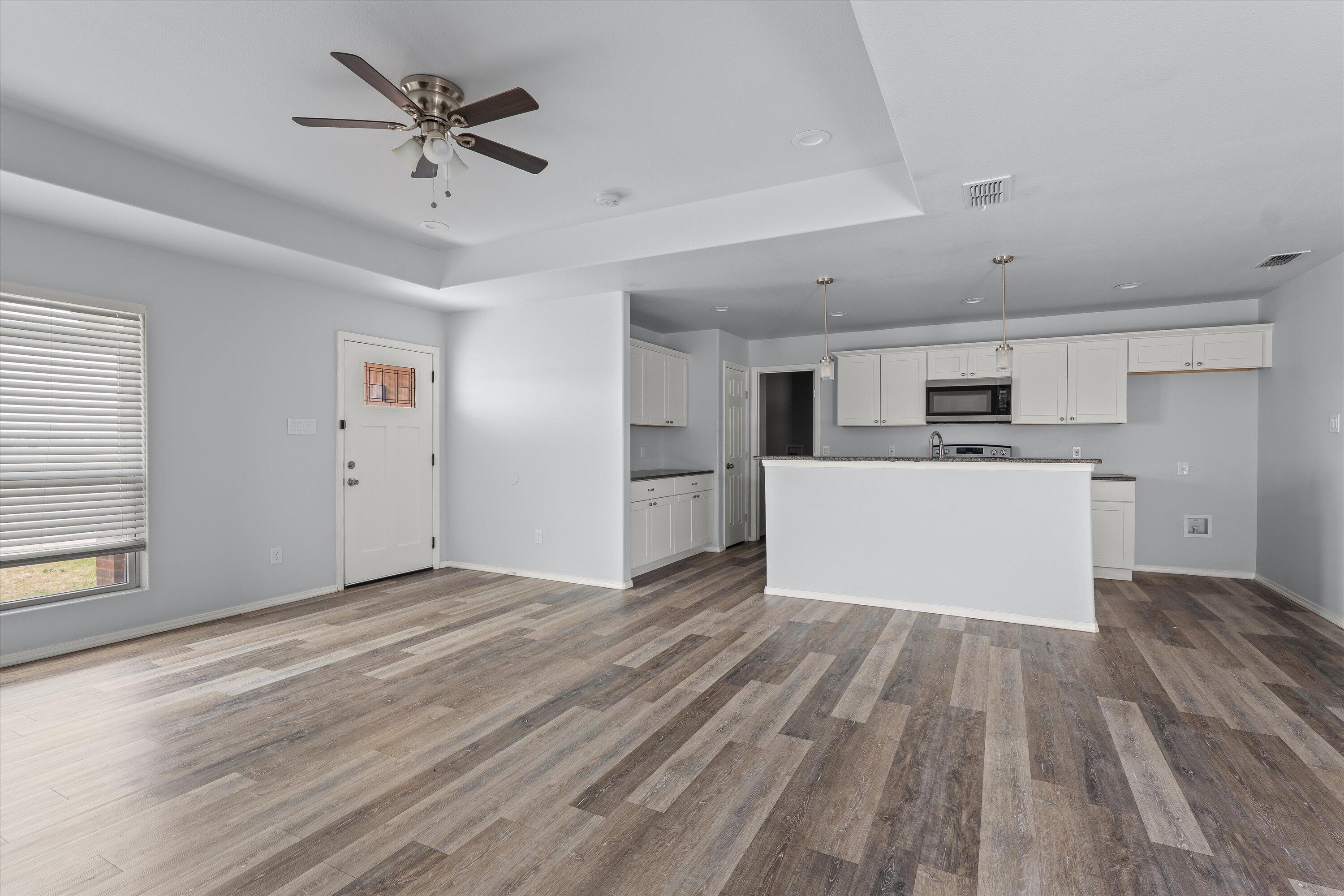 8414 11th Street Lubbock, TX 79416 - Photo 2 of 26 a view of a kitchen with a microwave and a stove top oven