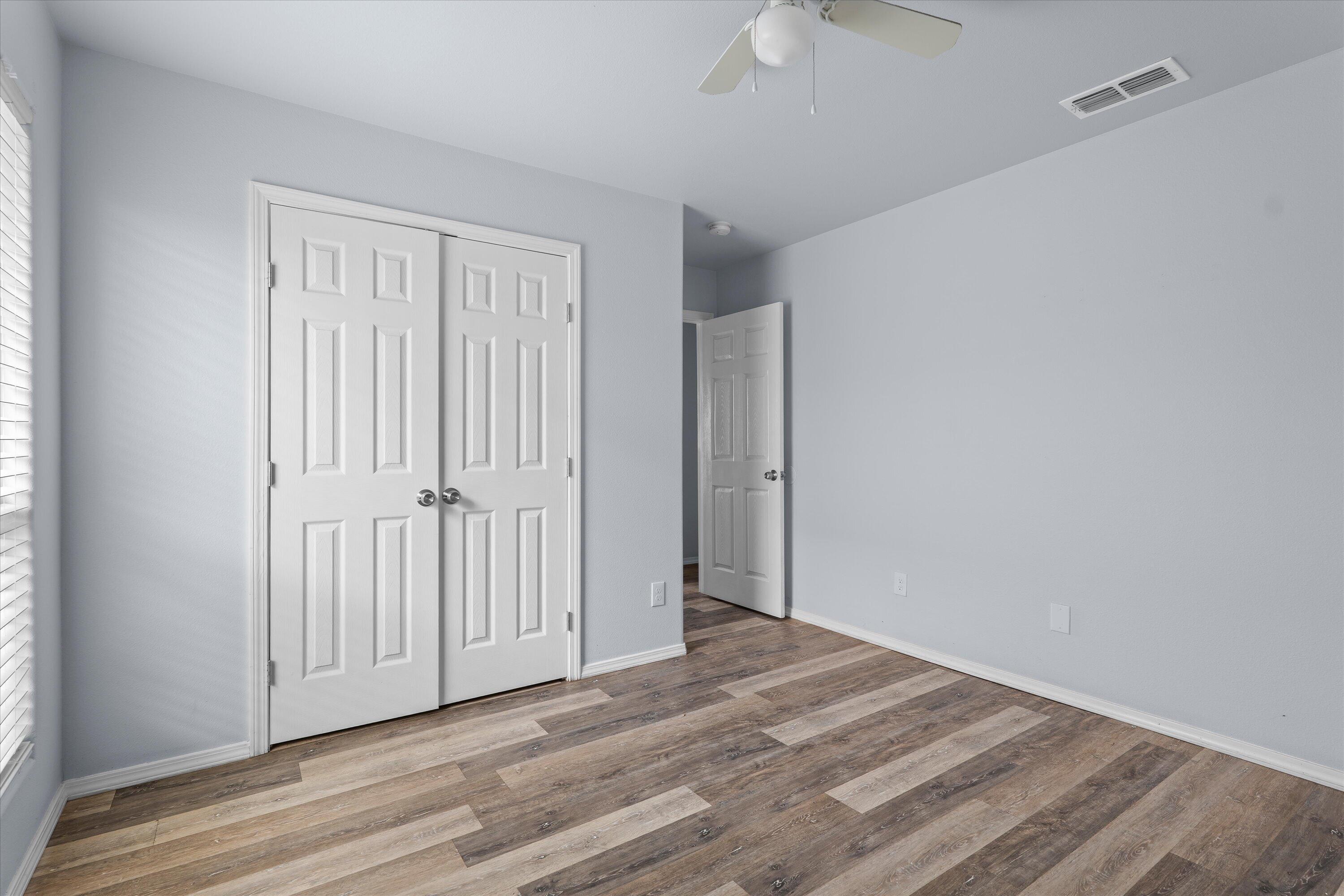 8414 11th Street Lubbock, TX 79416 - Photo 22 of 26 a view of a livingroom with wooden floor and a ceiling fan