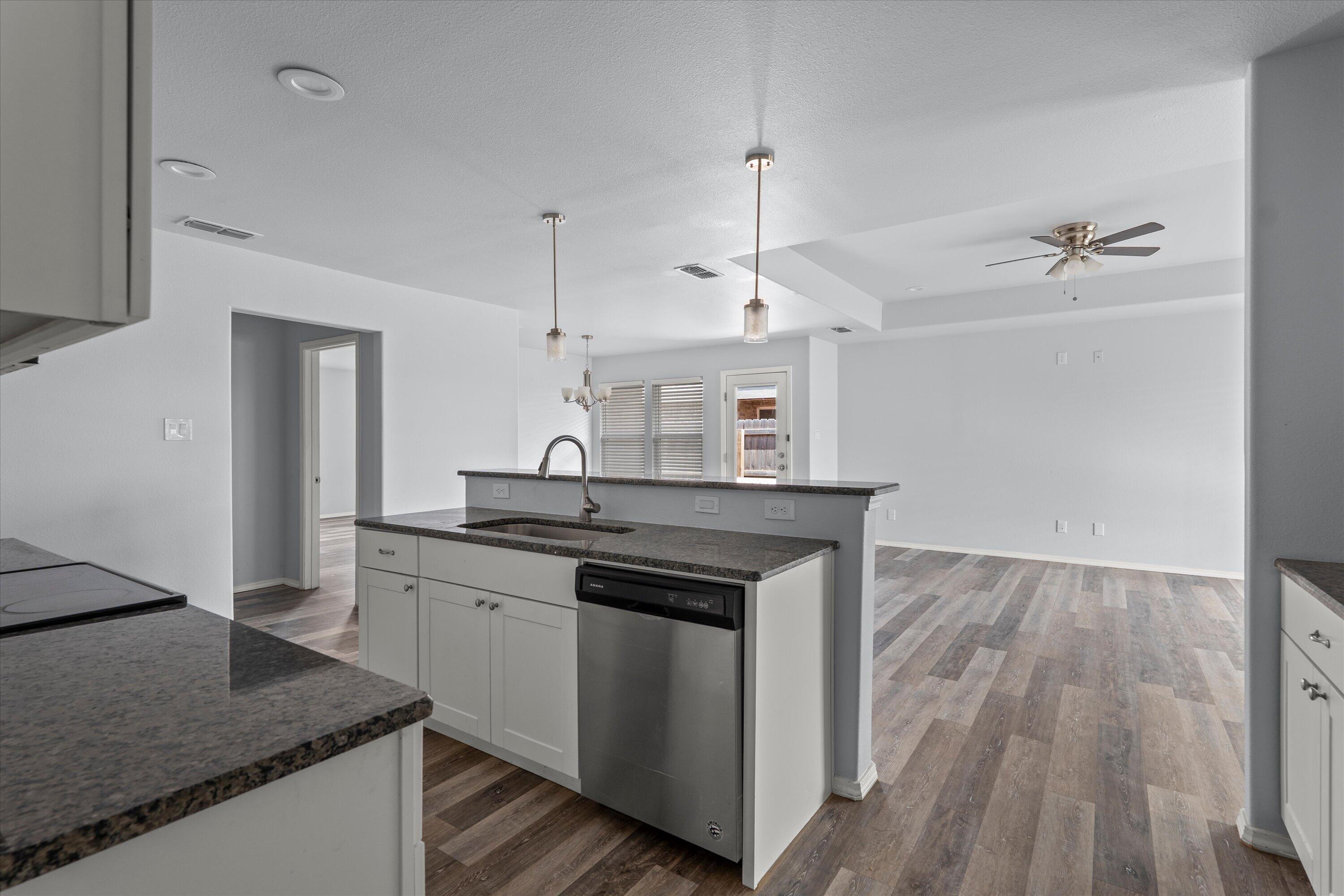 8414 11th Street Lubbock, TX 79416 - Photo 3 of 26 a kitchen with granite countertop a sink cabinets and wooden floor