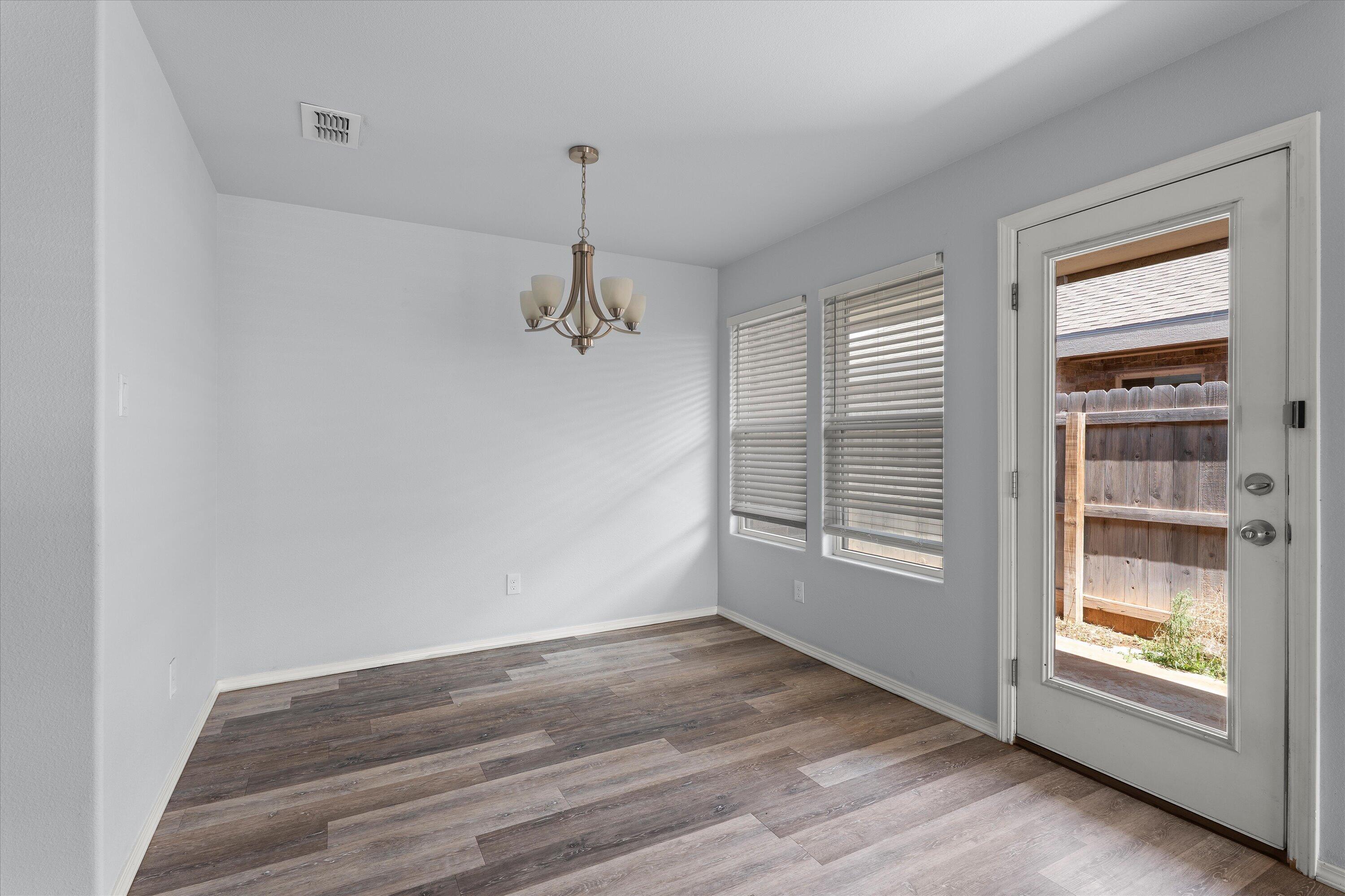 8414 11th Street Lubbock, TX 79416 - Photo 9 of 26 wooden floor in an empty room with a window