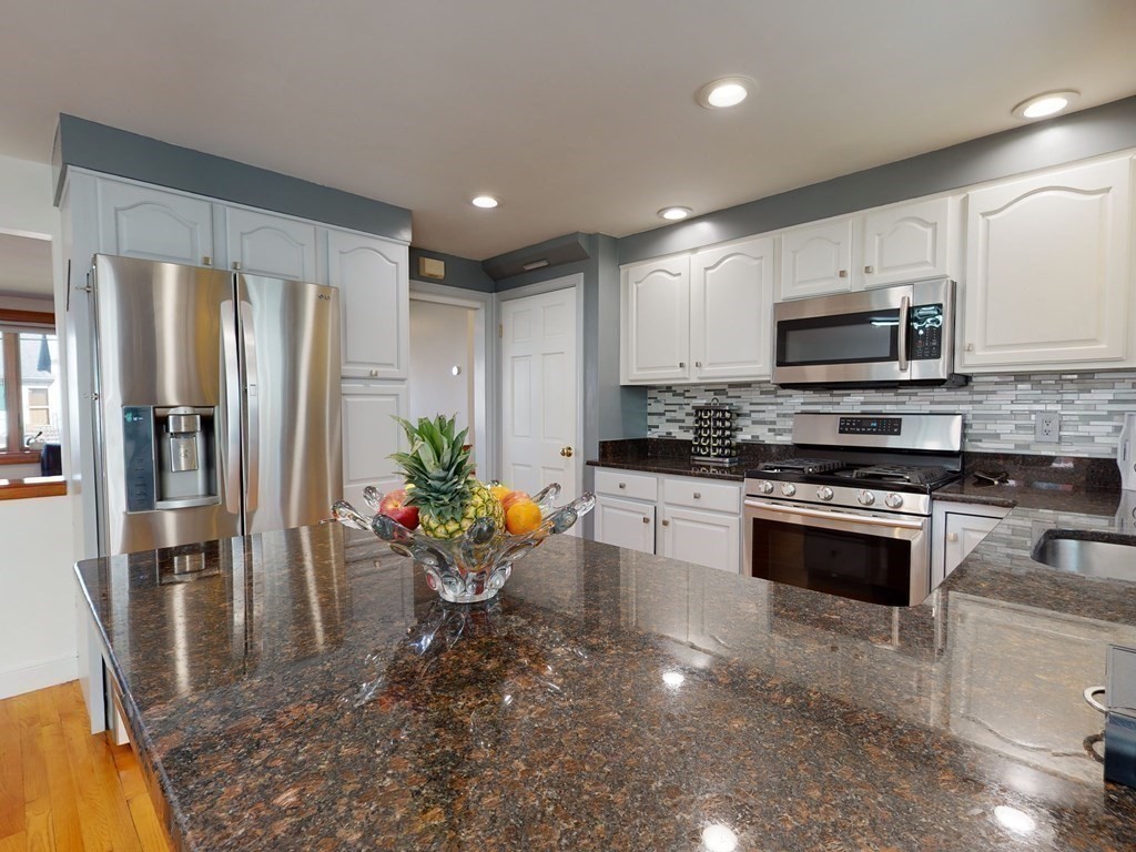 30 Kingston Road Waltham, MA 02451 - Photo 18 of 41 a kitchen with stainless steel appliances granite countertop a refrigerator a stove top oven a sink and dishwasher