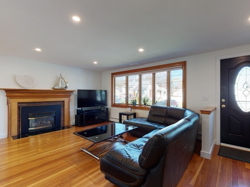 30 Kingston Road Waltham, MA 02451 - Photo 6 of 41 a living room with furniture a flat screen tv and a fireplace