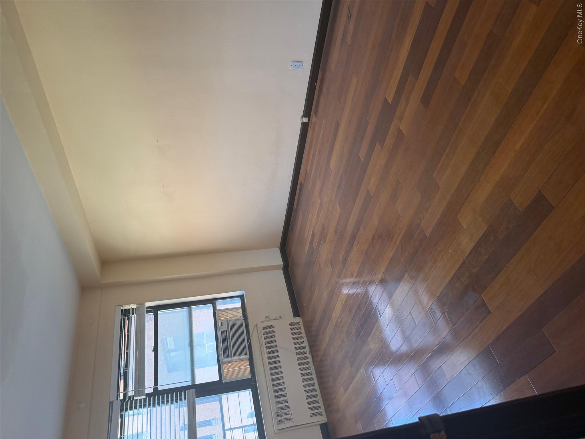 99-32 66th Road, Unit 3AA Queens, NY 11374 - Photo 6 of 9 a view of a livingroom with wooden floor and window