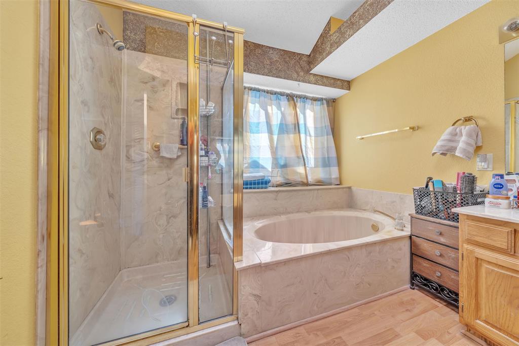3405 Tulip Lane Rowlett, TX 75089 - Photo 14 of 36 a bathroom with a tub a sink and mirrors