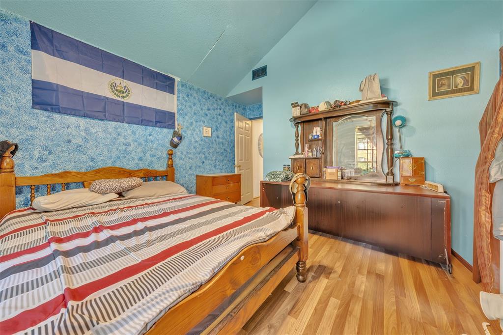 3405 Tulip Lane Rowlett, TX 75089 - Photo 19 of 36 a bedroom with a bed and wooden floor