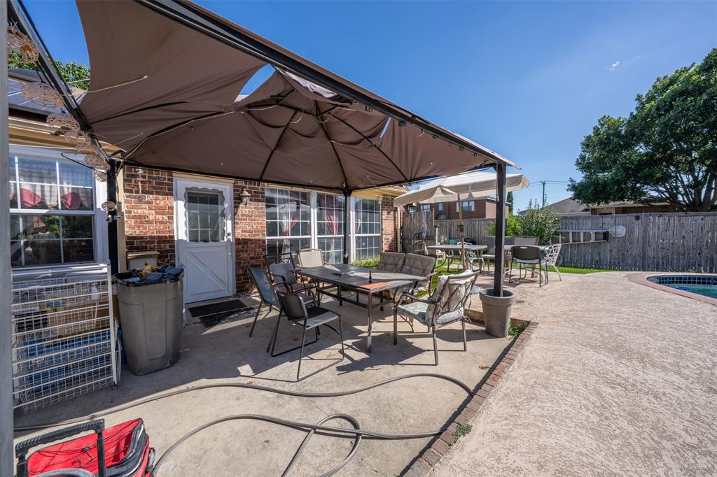 3405 Tulip Lane Rowlett, TX 75089 - Photo 25 of 36 a view of a patio with table and chairs under an umbrella