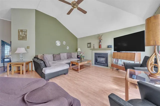 a living room with furniture a flat screen tv and a fireplace