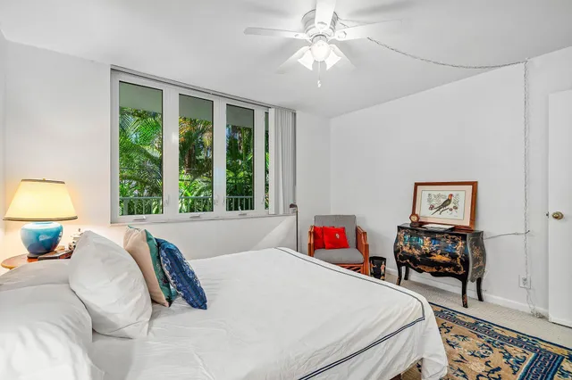 a bedroom with a bed and a large window