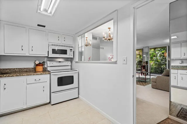 a kitchen with granite countertop white cabinets and white appliances