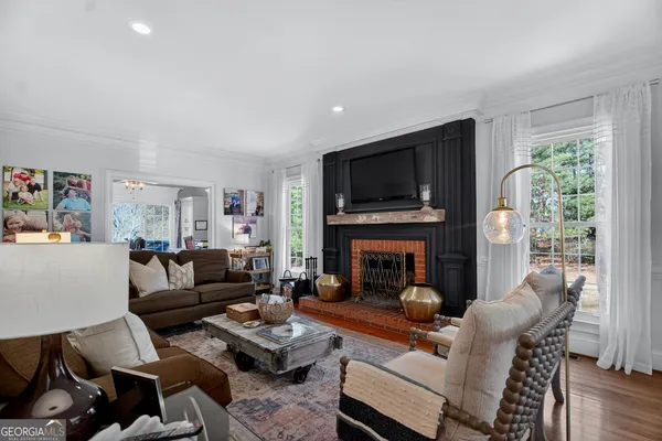 a living room with fireplace furniture and a wooden floor