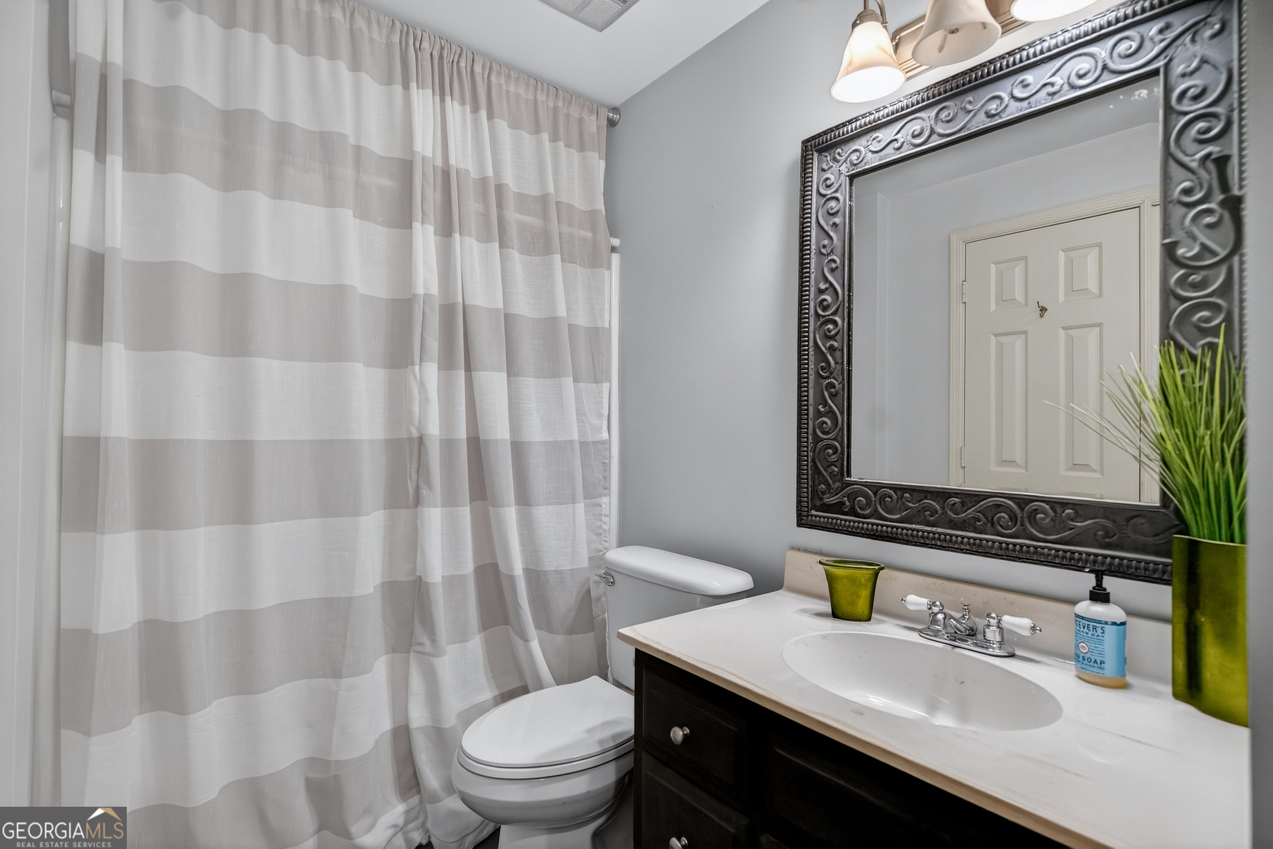 638 Cameron Mill Road LaGrange, GA 30240 - Photo 54 of 72 a bathroom with a sink a toilet a mirror and shower curtain