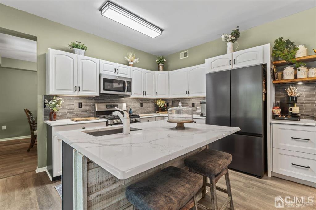 14 Reddington Drive Old Bridge, NJ 07747 - Photo 23 of 40 a kitchen with stainless steel appliances granite countertop a refrigerator a stove a sink a dining table and chairs