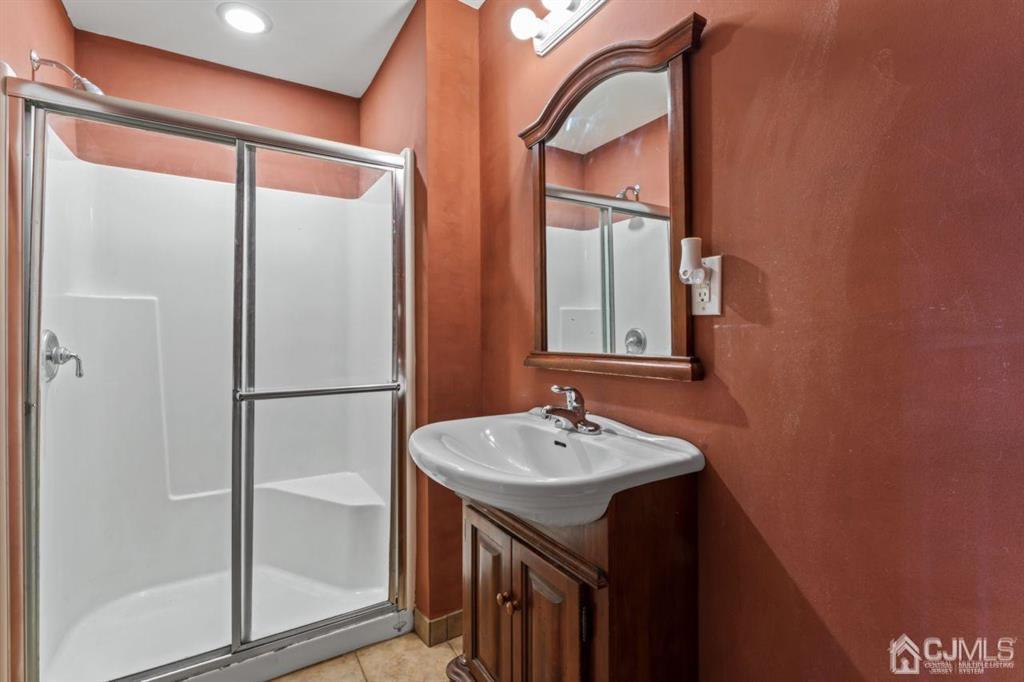14 Reddington Drive Old Bridge, NJ 07747 - Photo 10 of 40 a bathroom with a sink a mirror and a shower