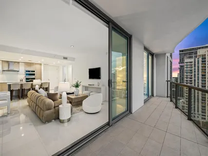 a living room with furniture a flat screen tv and a large window