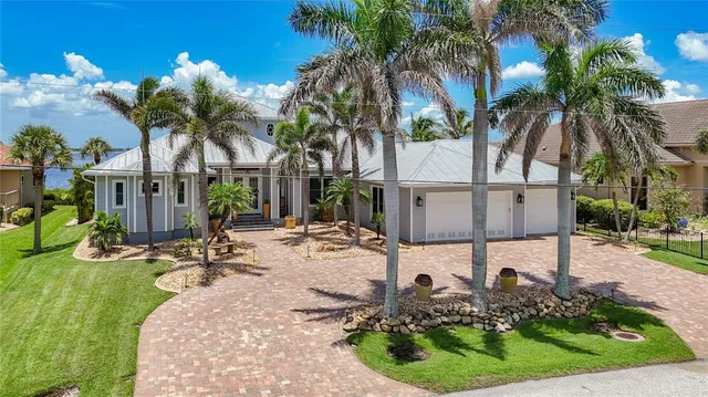 front view of house with a yard and palm trees