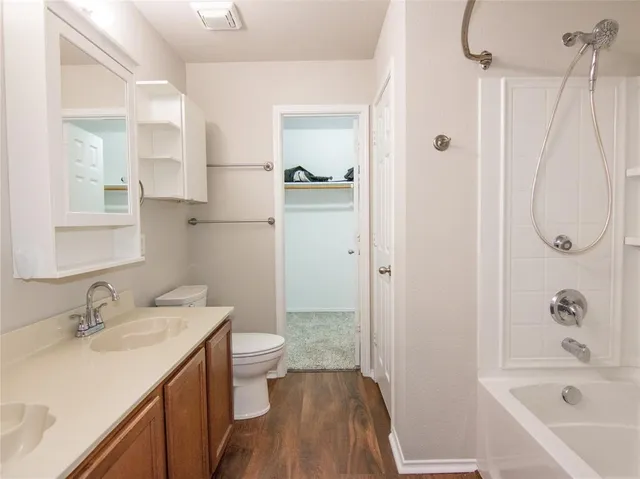 a bathroom with a granite countertop sink a toilet and shower