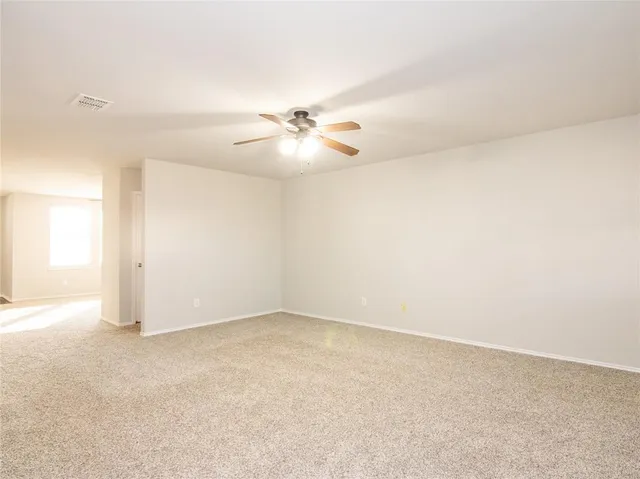 an empty room with fan and a ceiling fan