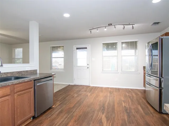 a kitchen with granite countertop a sink and wooden floor