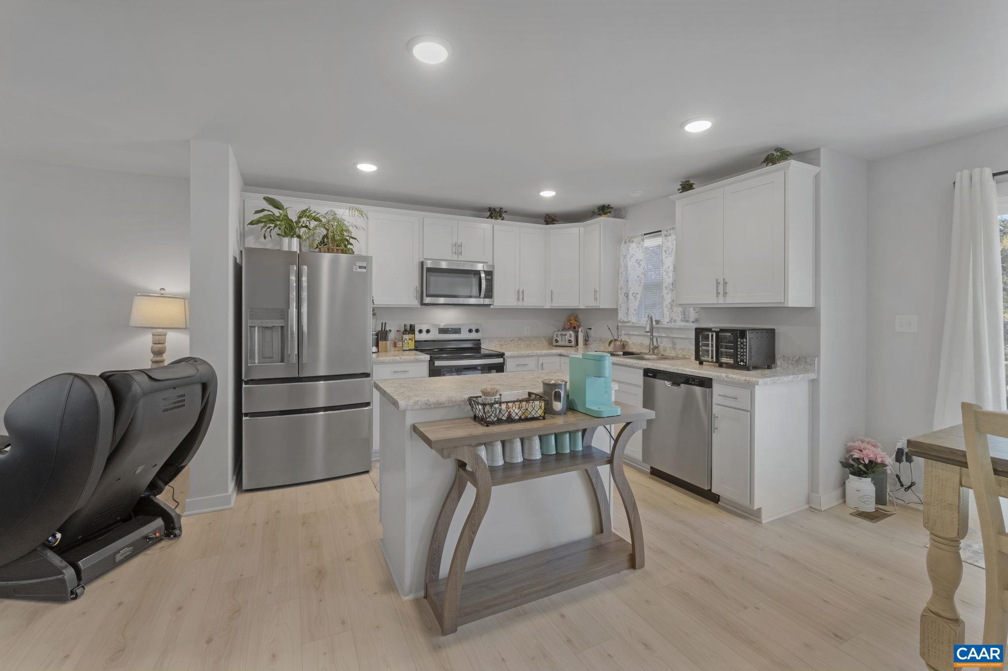 7440 Louisa Road Gordonsville, VA 22942 - Photo 13 of 40 a kitchen with a refrigerator a stove a sink a dining table and chairs