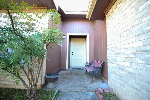 a view of a porch with red door and chair
