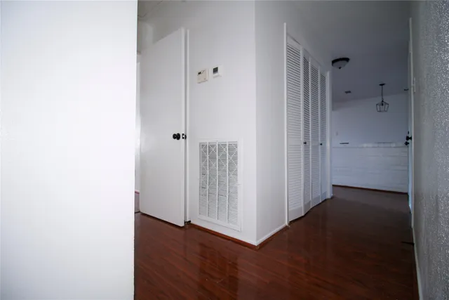 a view of a hallway with wooden floor