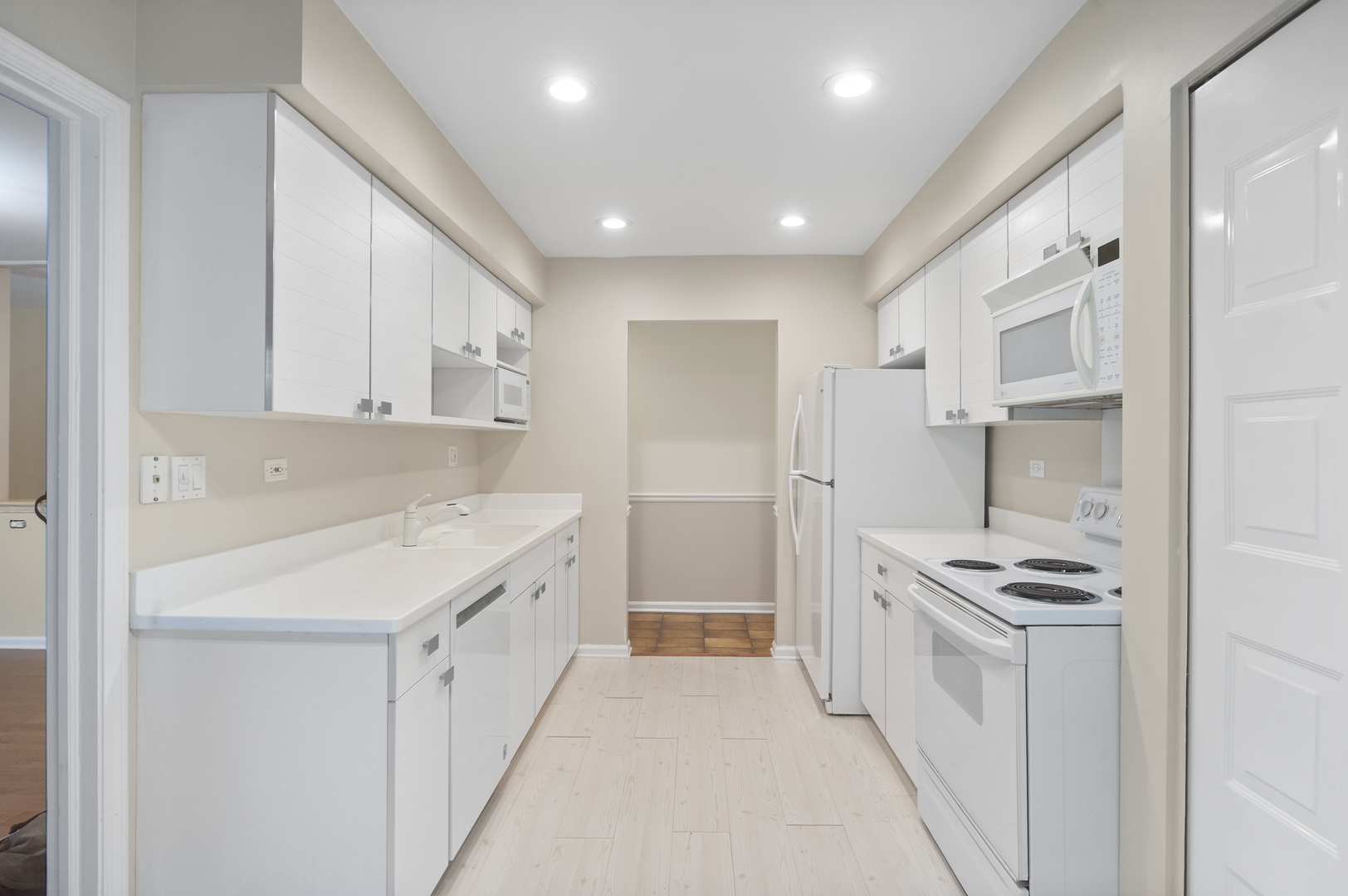 4949 Golf Road, Unit 101 Skokie, IL 60077 - Photo 7 of 22 a kitchen with white cabinets and appliances
