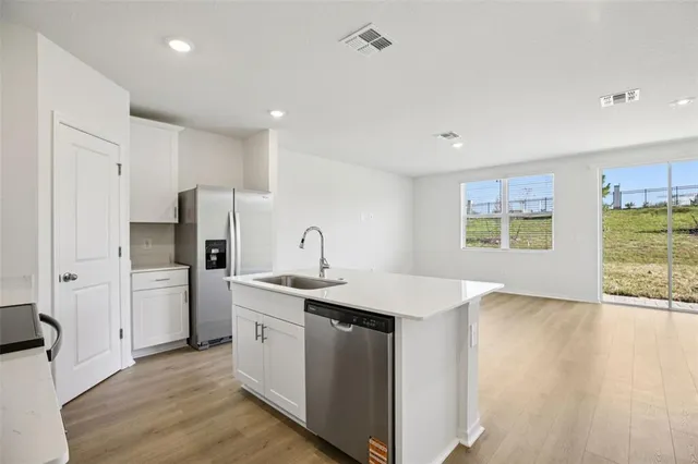 a kitchen with a sink a refrigerator and window