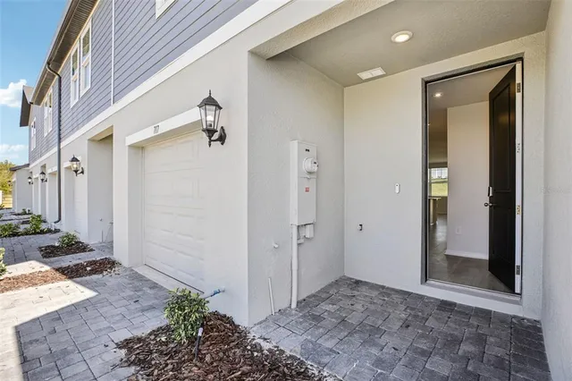 a view of a hallway with potted plants in front of door