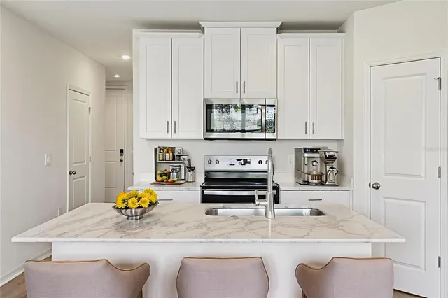 a kitchen with stainless steel appliances a sink a stove a microwave a sink and cabinets