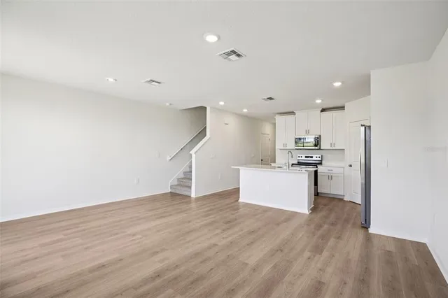 a view of kitchen with wooden floor and electronic appliances