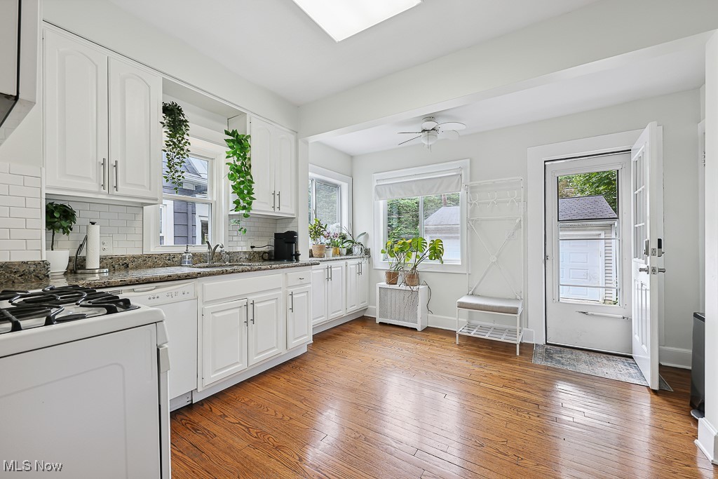 3266 Avalon Road Cleveland, OH 44120 - Photo 28 of 46 Kitchen featuring white appliances, backsplash, light wood-style flooring, white cabinets, and radiator heating unit