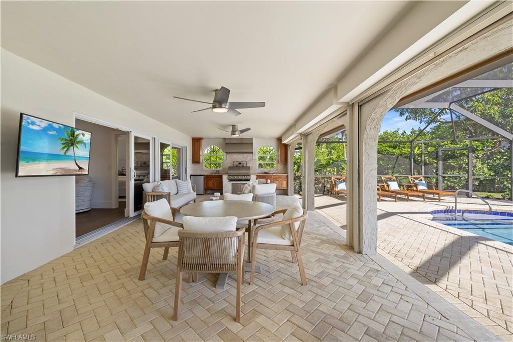 4916 Crayton Road Naples, FL 34103 - Photo 19 of 34 a view of a dining room with furniture large windows and wooden floor