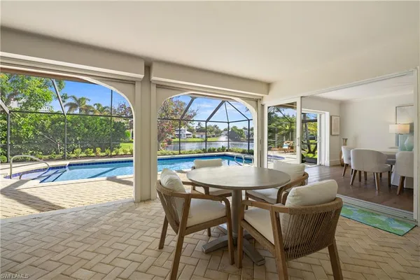 a dining room with furniture a chandelier and wooden floor