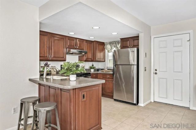 a kitchen with stainless steel appliances granite countertop a refrigerator a stove a sink and a microwave