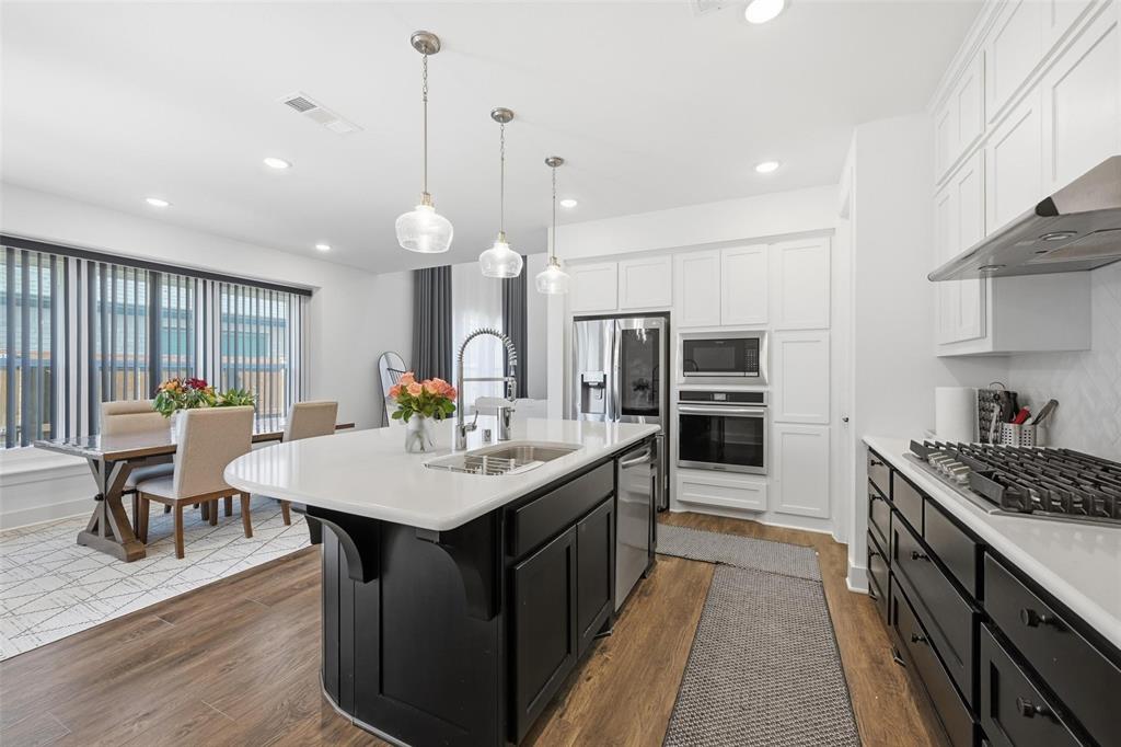 2416 Gallions Road Celina, TX 75009 - Photo 6 of 33 a kitchen with counter space sink stove and wooden floor