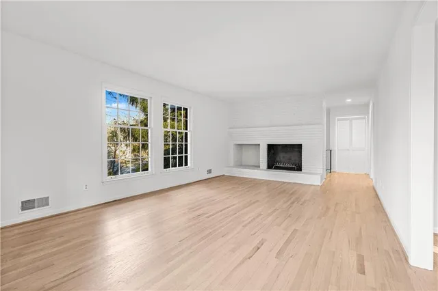 a view of empty room with wooden floor and fireplace