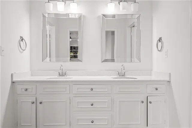a bathroom with double sink and a mirror