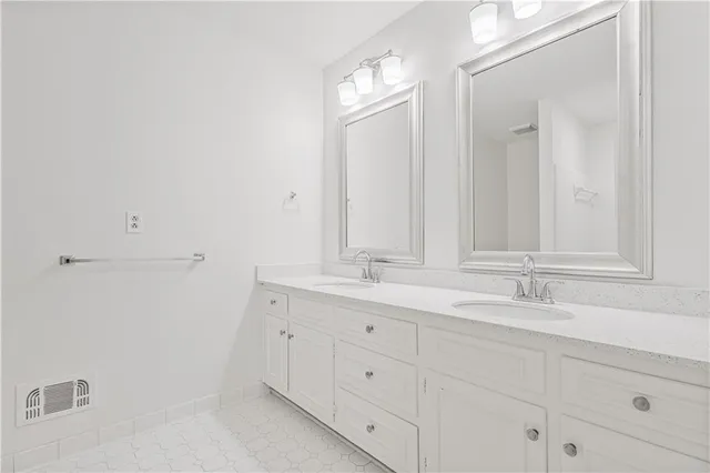 a bathroom with double sink and a mirror