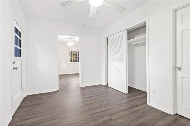 an empty room with wooden floor & windows