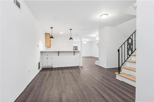 a view of a kitchen with wooden floor and electronic appliances