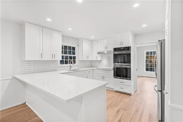 a kitchen with stainless steel appliances a refrigerator and a stove top oven